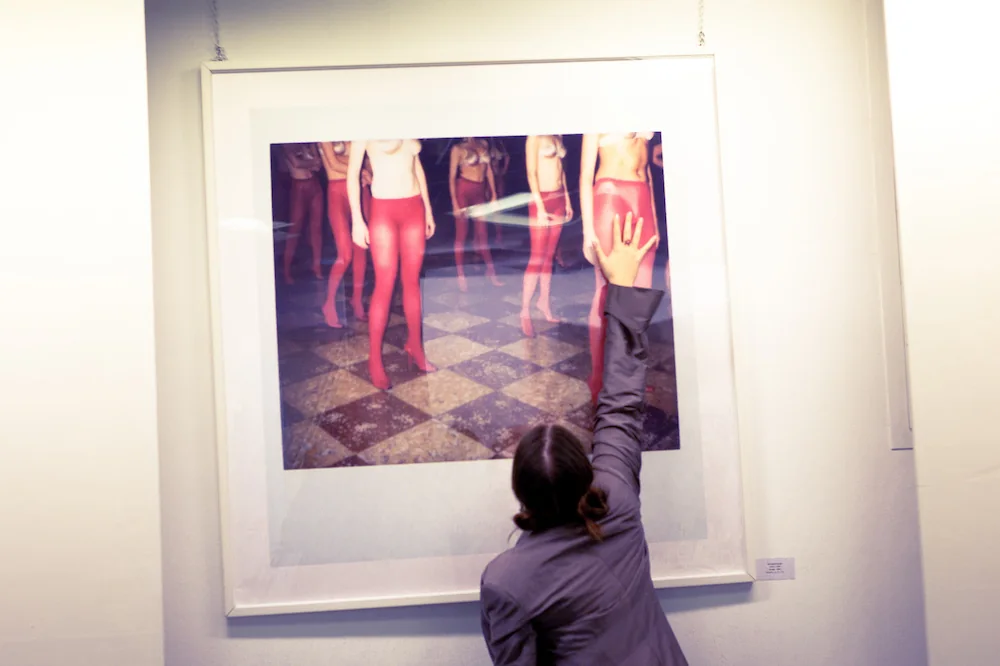 Una persona osserva una fotografia durante una visita a una mostra